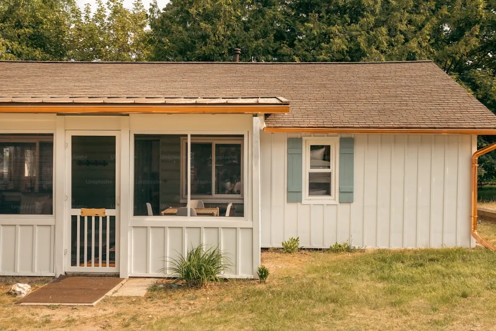 a small white house with a porch and a covered porch